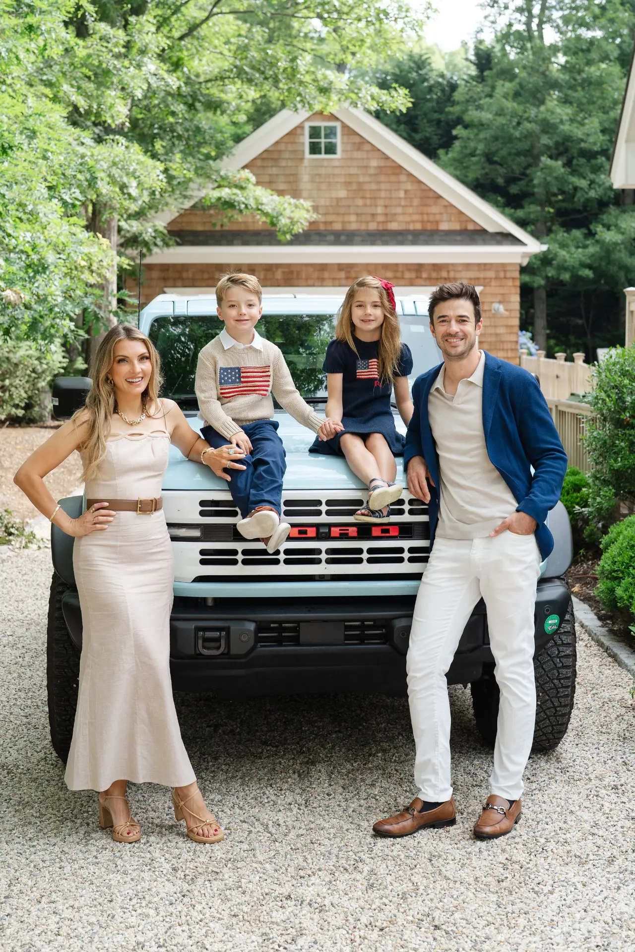 Anthony Kennada with his wife and two children in front of a vintage blue Bronco